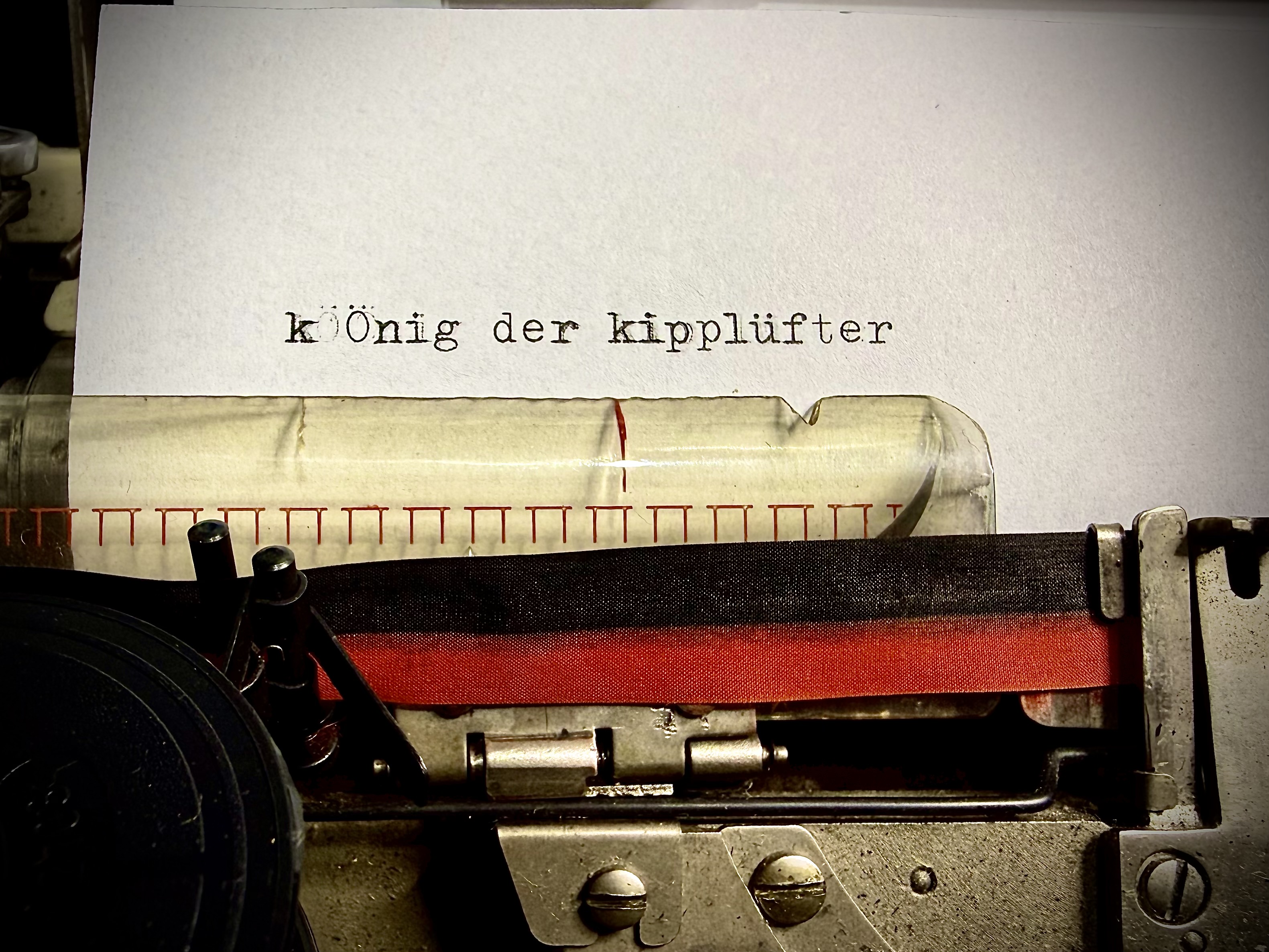 Cover von König der Kipplüfter – eine Schreibmaschine, in die das Wort 'König der Kipplüfter' getippt wird